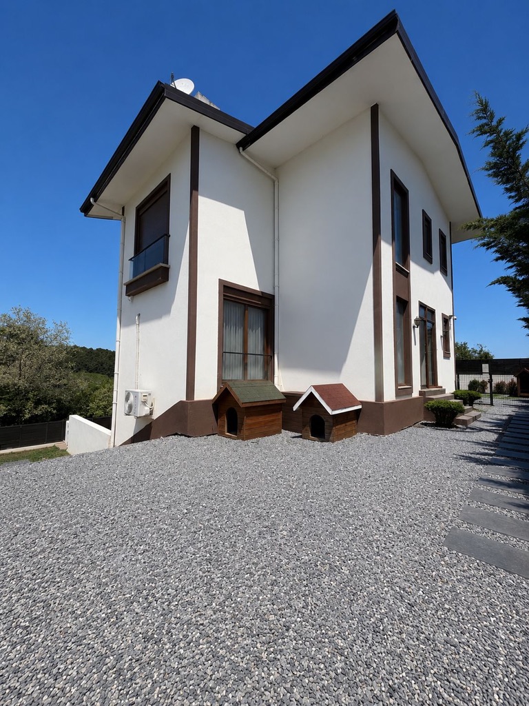 Villanın dış cephesi ve çakıl zeminli bahçe